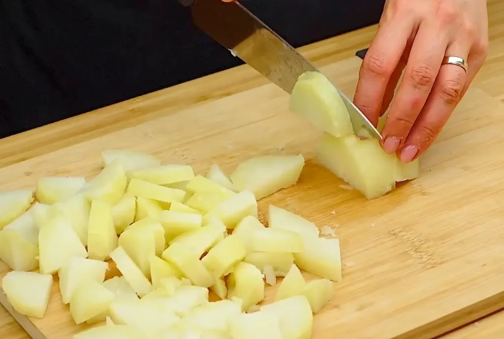 cutting the boiled potatoes for preparing salad