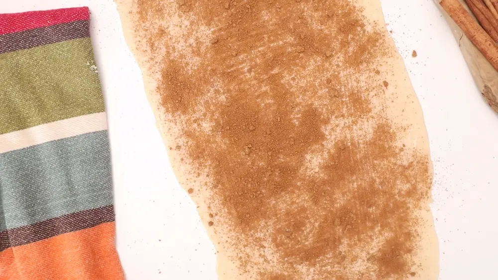 spreading Cinnamon over Pie Crust Cinnamon Rolls