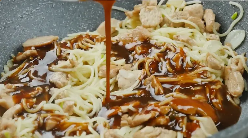 adding Chow Mein sauce to chicken and veggies