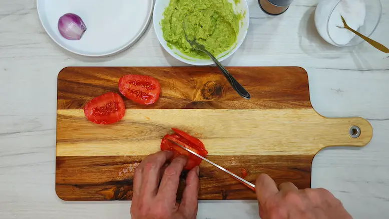 slicing tomato for making avocado making Guacamole
