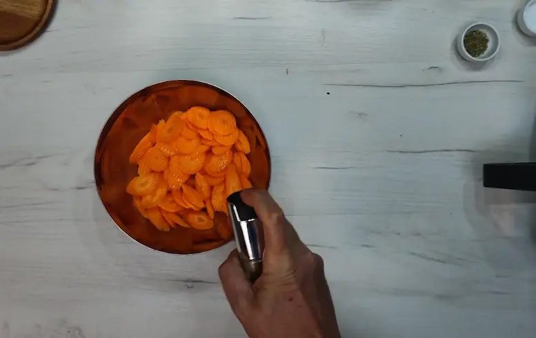 spraying oil at Carrot Chips for air frying